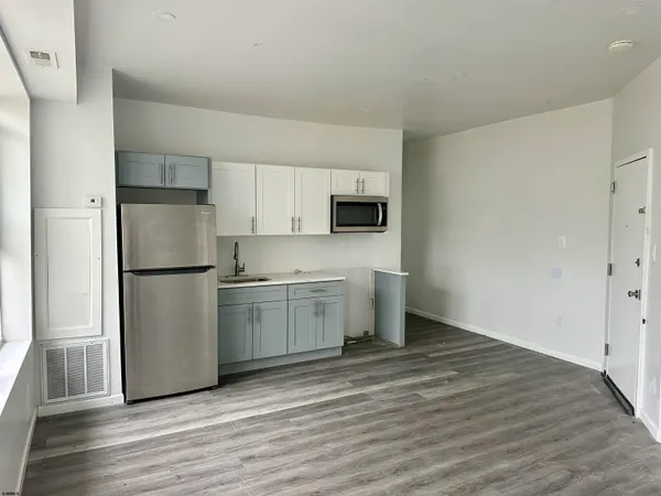 a kitchen with a refrigerator sink and cabinets