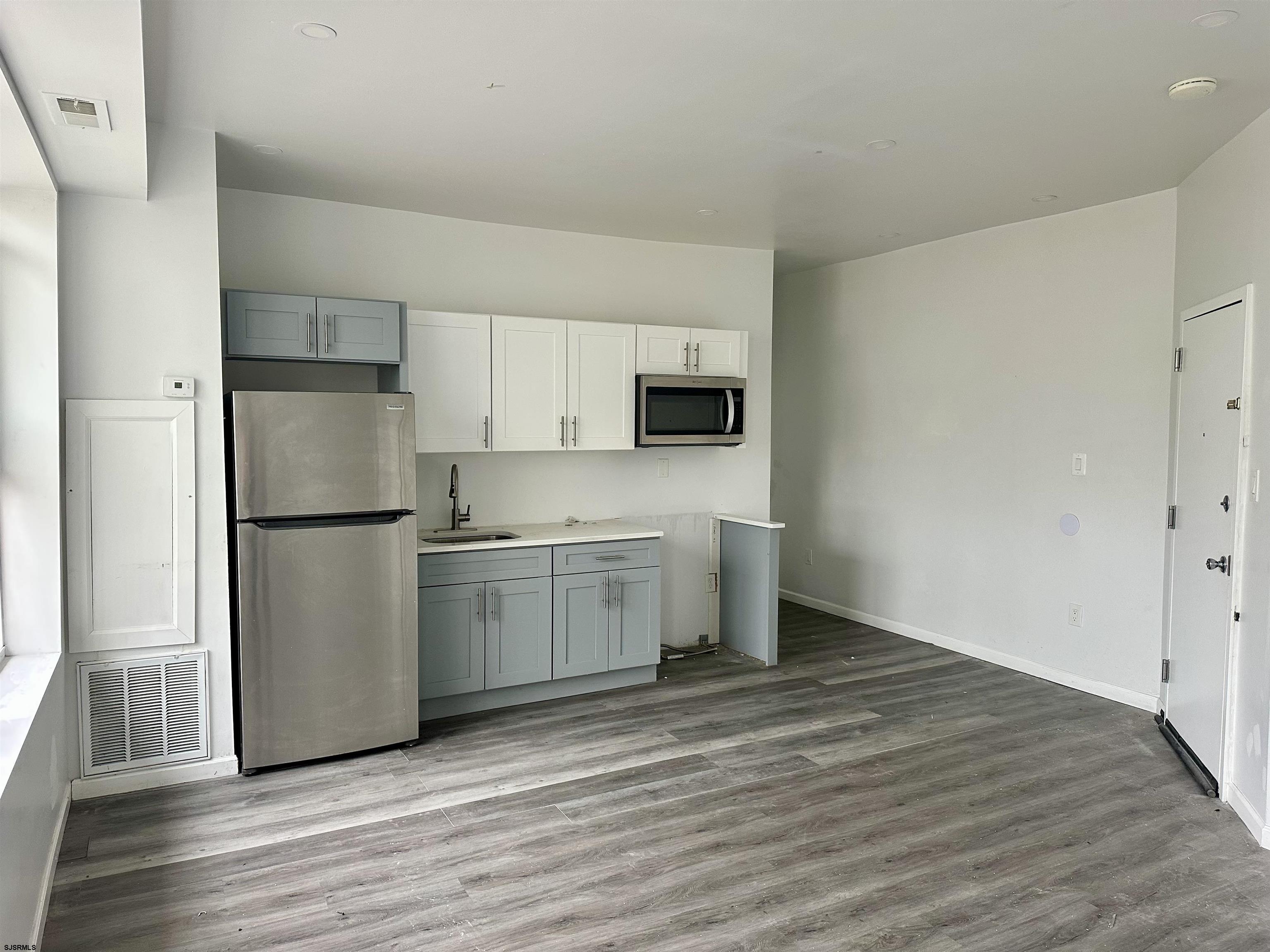 a kitchen with a refrigerator sink and cabinets