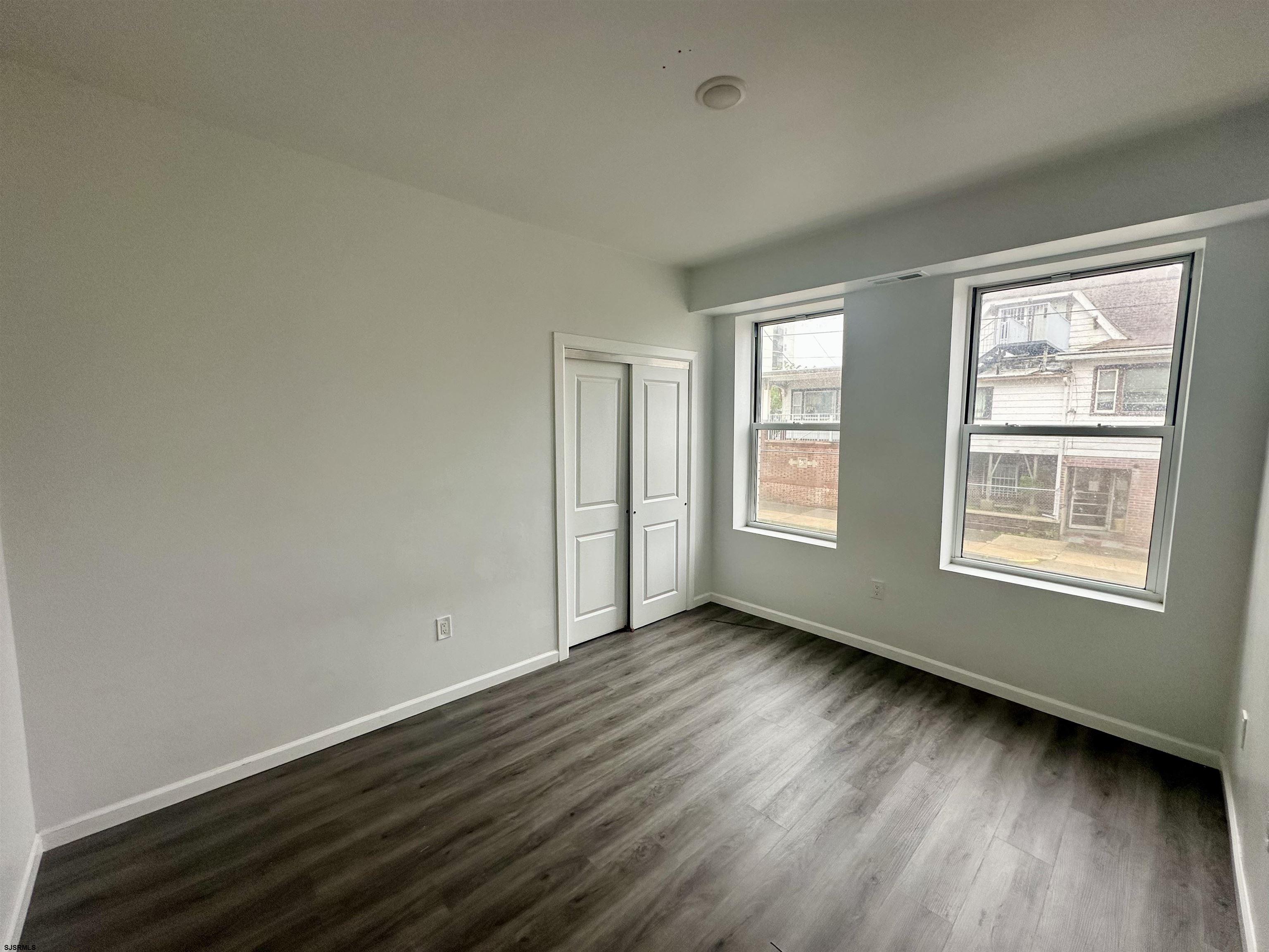 225 Atlantic Avenue, Unit A6 Atlantic City, NJ 08401 - Photo 3 of 29 a view of an empty room with wooden floor and a window