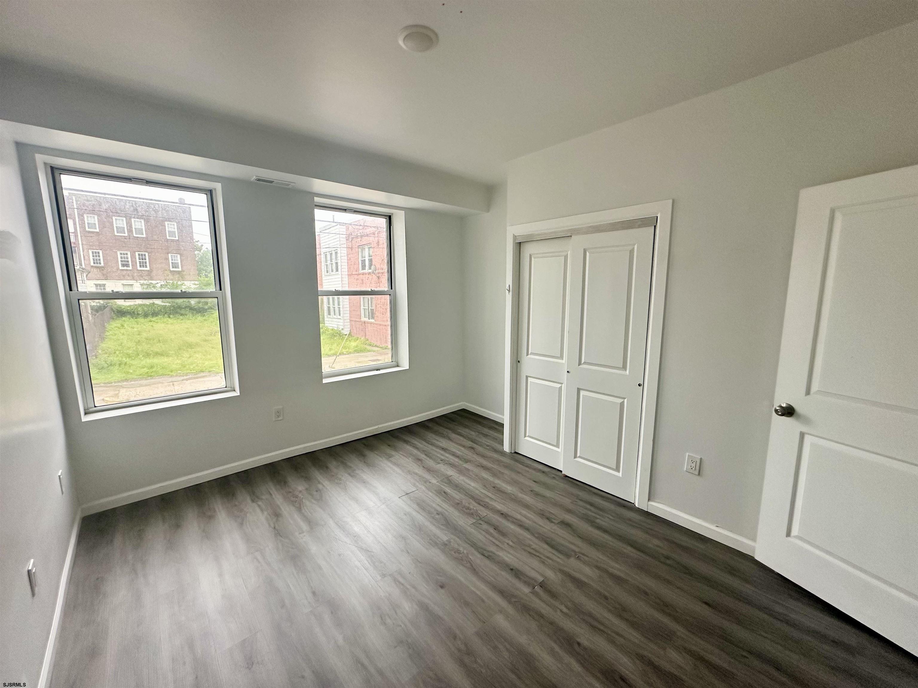 225 Atlantic Avenue, Unit A6 Atlantic City, NJ 08401 - Photo 4 of 29 a view of an empty room with wooden floor and a window
