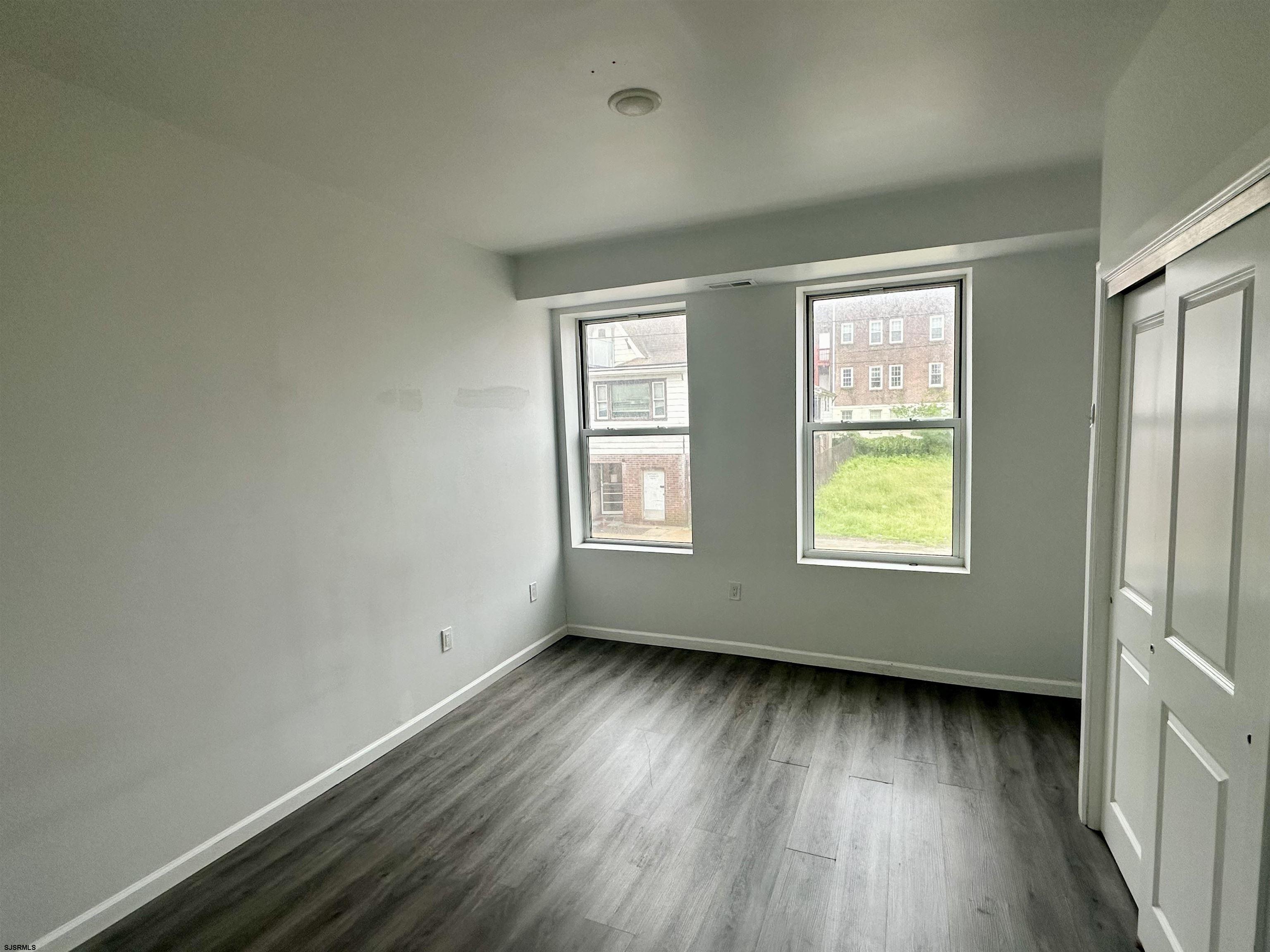 225 Atlantic Avenue, Unit A6 Atlantic City, NJ 08401 - Photo 5 of 29 an empty room with wooden floor and windows