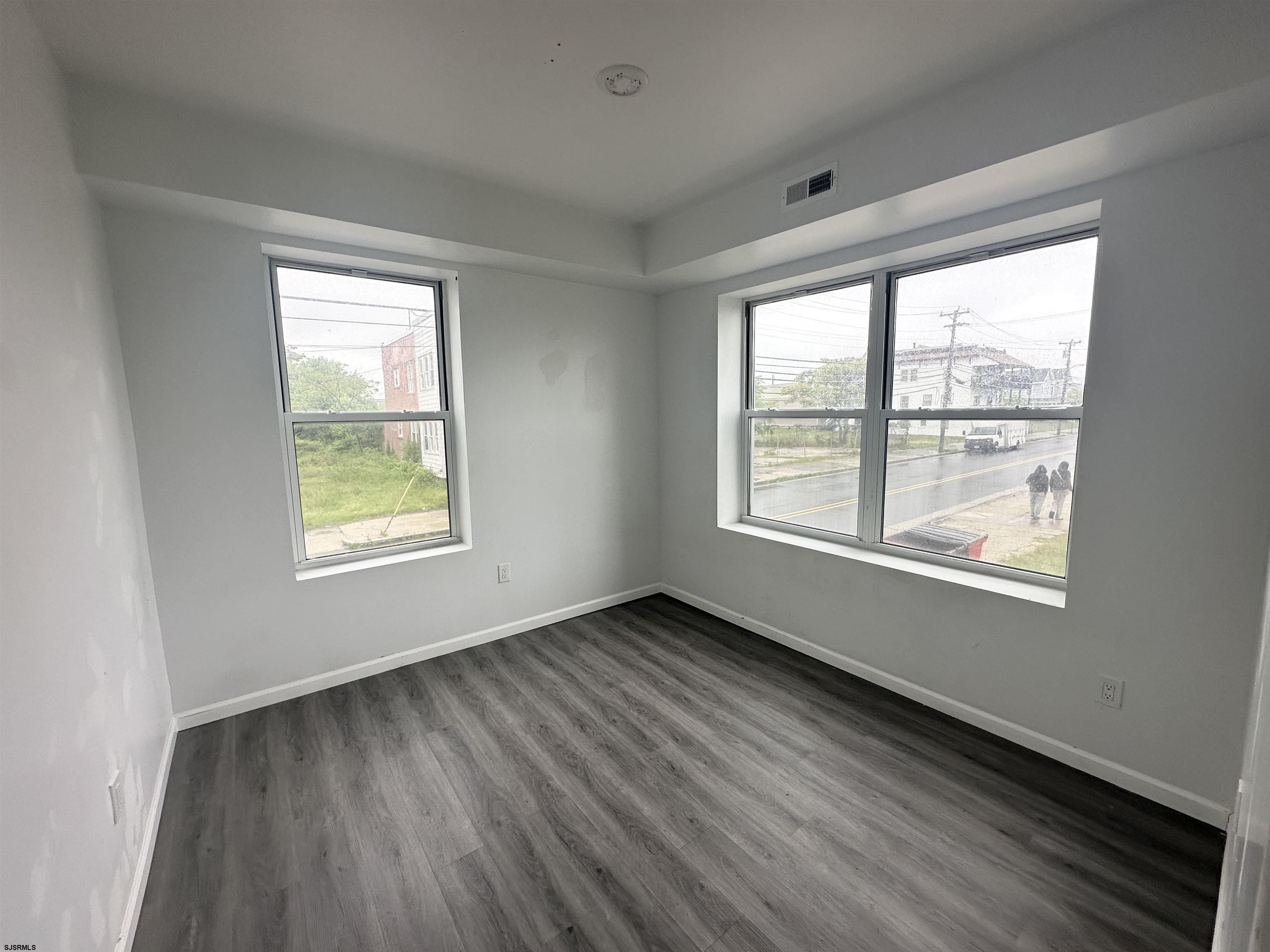 225 Atlantic Avenue, Unit A6 Atlantic City, NJ 08401 - Photo 9 of 29 a view of an empty room with wooden floor and a window