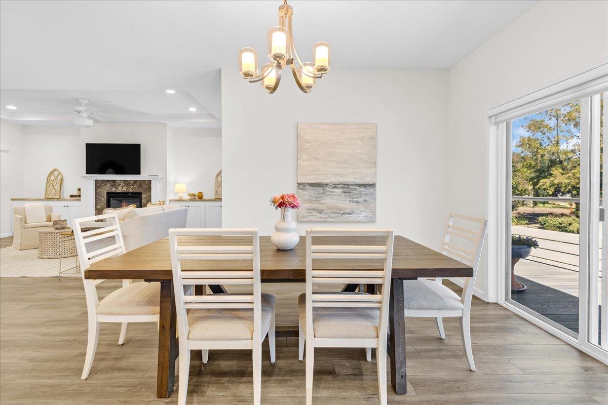 225 Mt Hermon Road, Unit 88 Scotts Valley, CA 95066 - Photo 19 of 50 a dining room with wooden floor a chandelier a wooden table and chairs