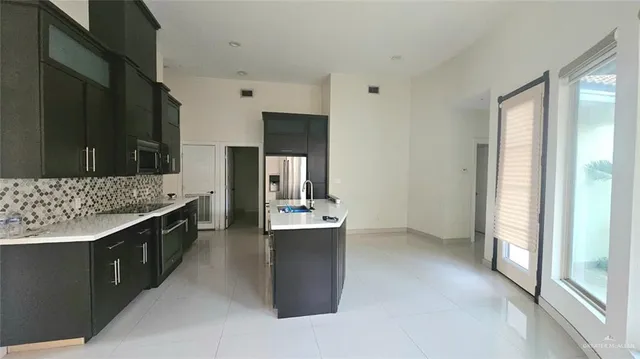a large kitchen with a large window and stainless steel appliances