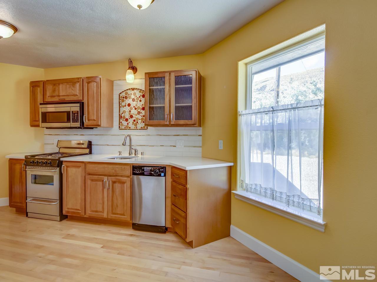 20575 Cooke Drive Reno, NV 89521 - Photo 17 of 25 a kitchen with stainless steel appliances granite countertop a stove a sink and a microwave