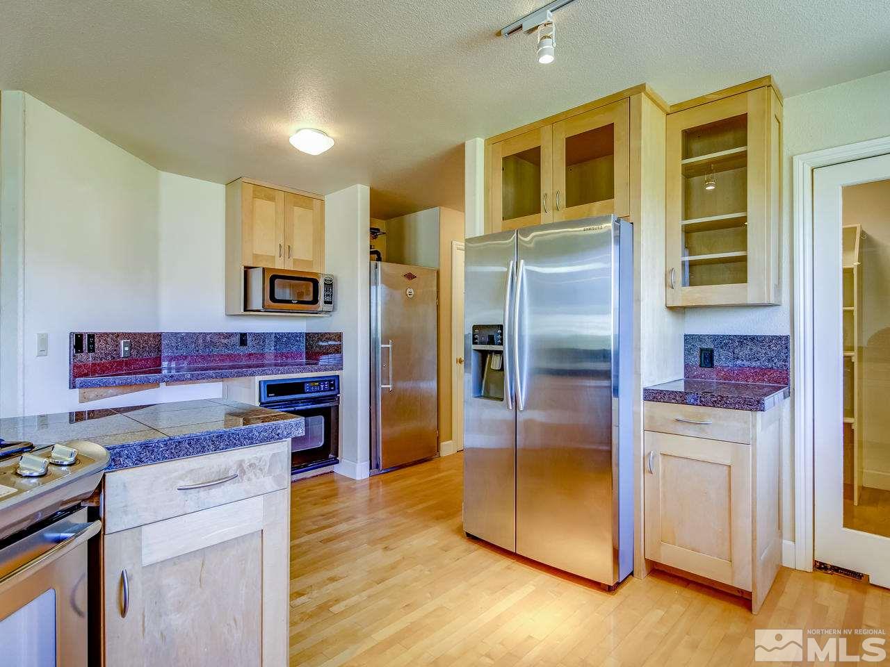 20575 Cooke Drive Reno, NV 89521 - Photo 6 of 25 a kitchen with stainless steel appliances granite countertop a refrigerator and a stove