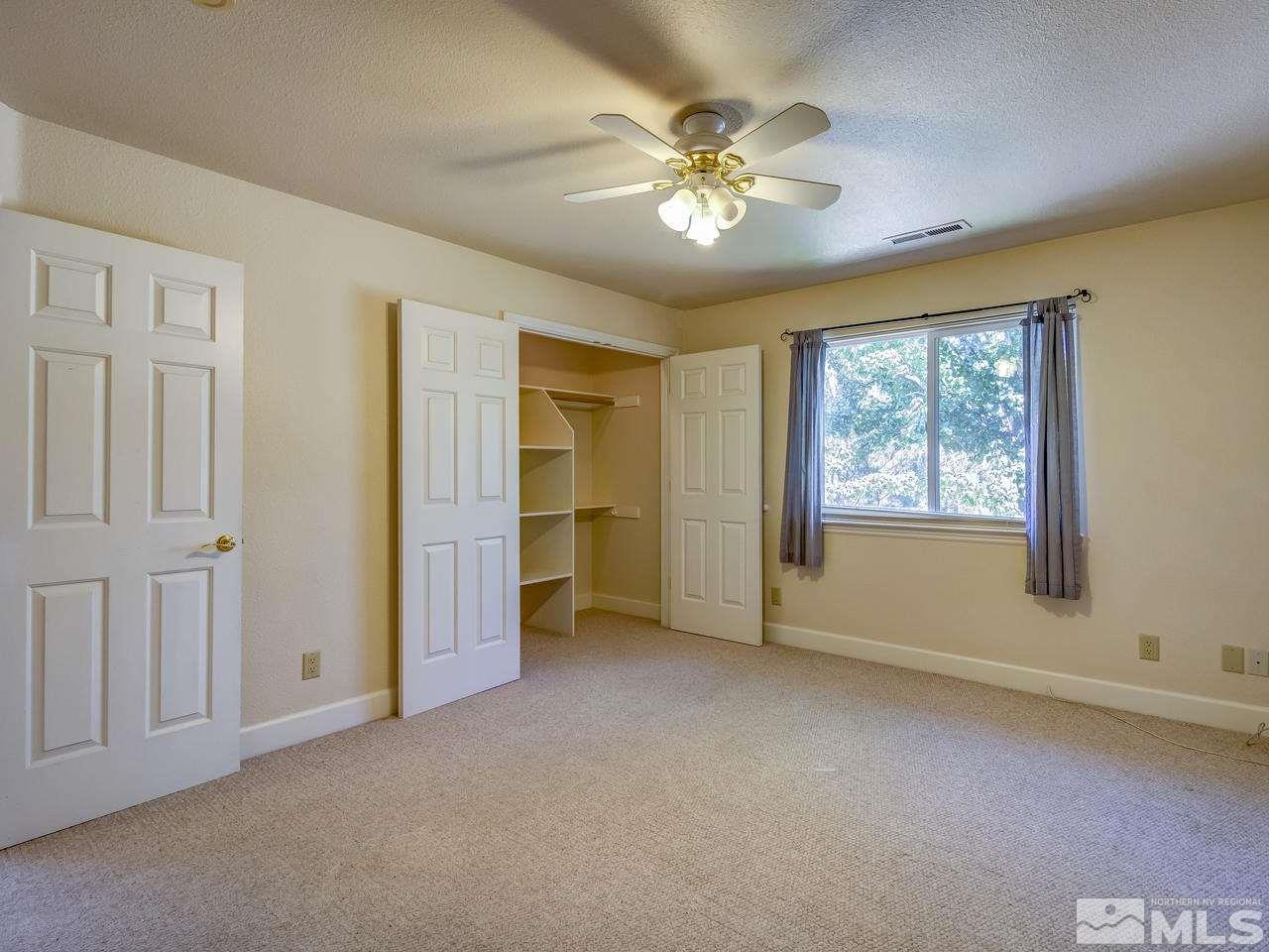 20575 Cooke Drive Reno, NV 89521 - Photo 10 of 25 an empty room with chandelier fan and windows