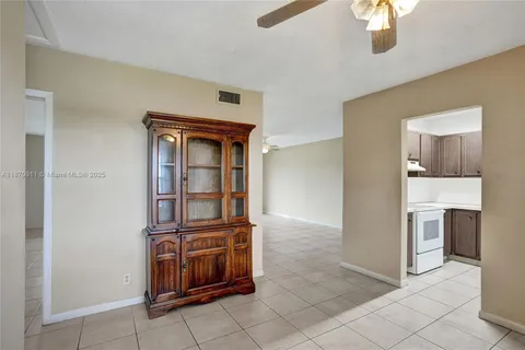 a view of kitchen with granite countertop cabinets and refrigerator