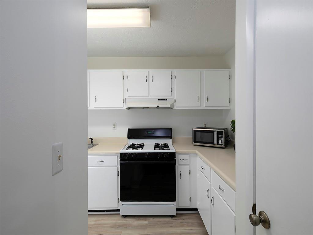 1316 Wynnes Ridge Circle Southeast Marietta, GA 30067 - Photo 14 of 29 a kitchen with granite countertop white cabinets and black appliances