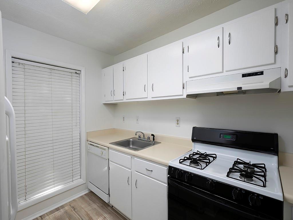 1316 Wynnes Ridge Circle Southeast Marietta, GA 30067 - Photo 15 of 29 a kitchen with white cabinets and black appliances