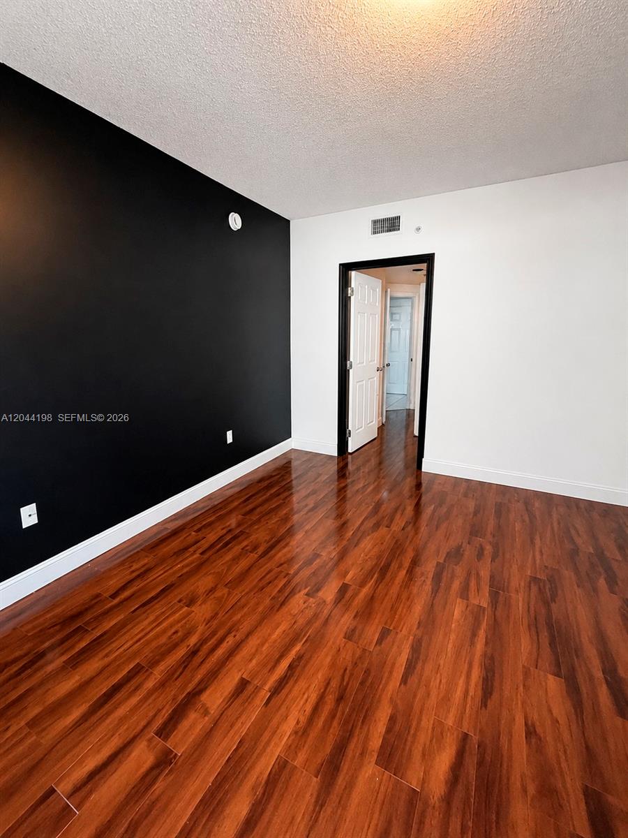 17145 North Bay Road, Unit 4307 Sunny Isles Beach, FL 33160 - Photo 10 of 35 a view of an empty room with wooden floor