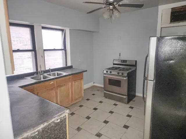 a kitchen with granite countertop a stove a sink and a refrigerator