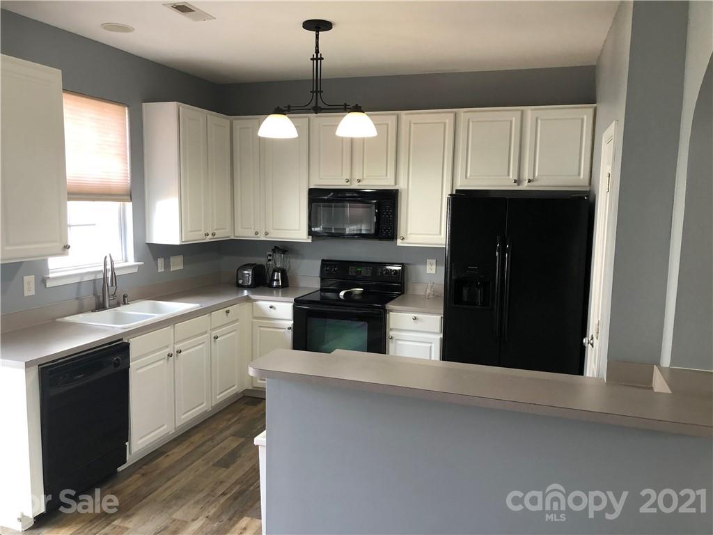 123 Chimney Rock Lane Fort Mill, SC 29708 - Photo 2 of 30 a kitchen with stainless steel appliances granite countertop a refrigerator a sink a stove a microwave and wooden cabinets