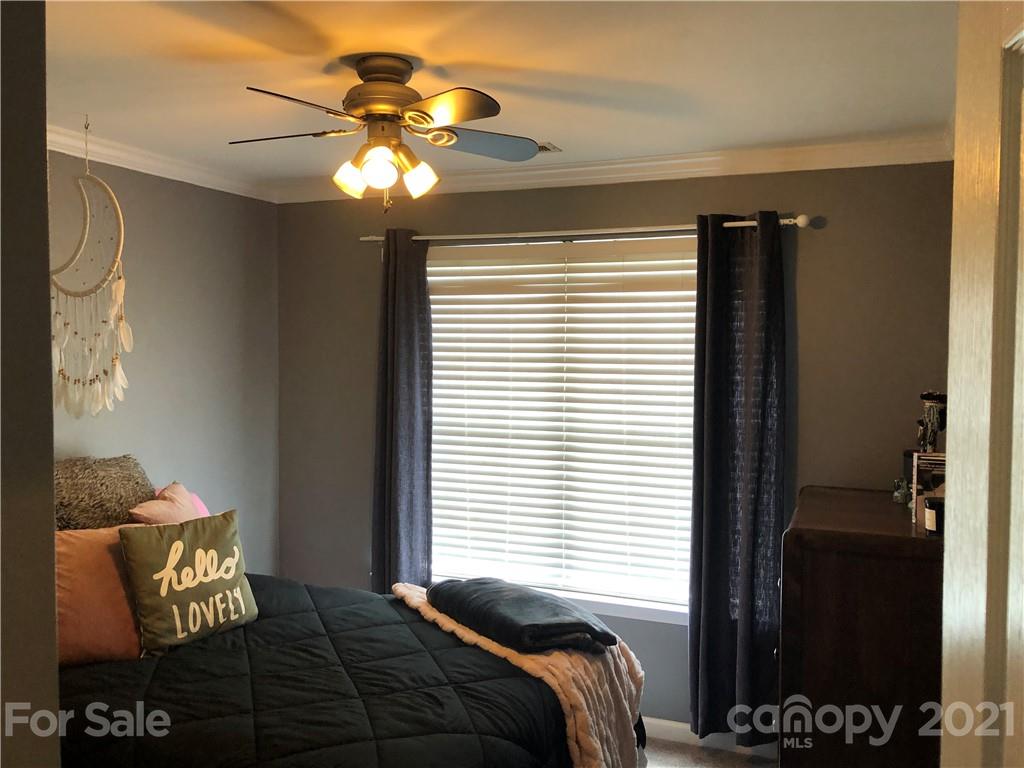 123 Chimney Rock Lane Fort Mill, SC 29708 - Photo 18 of 30 a bedroom with a bed and a chandelier