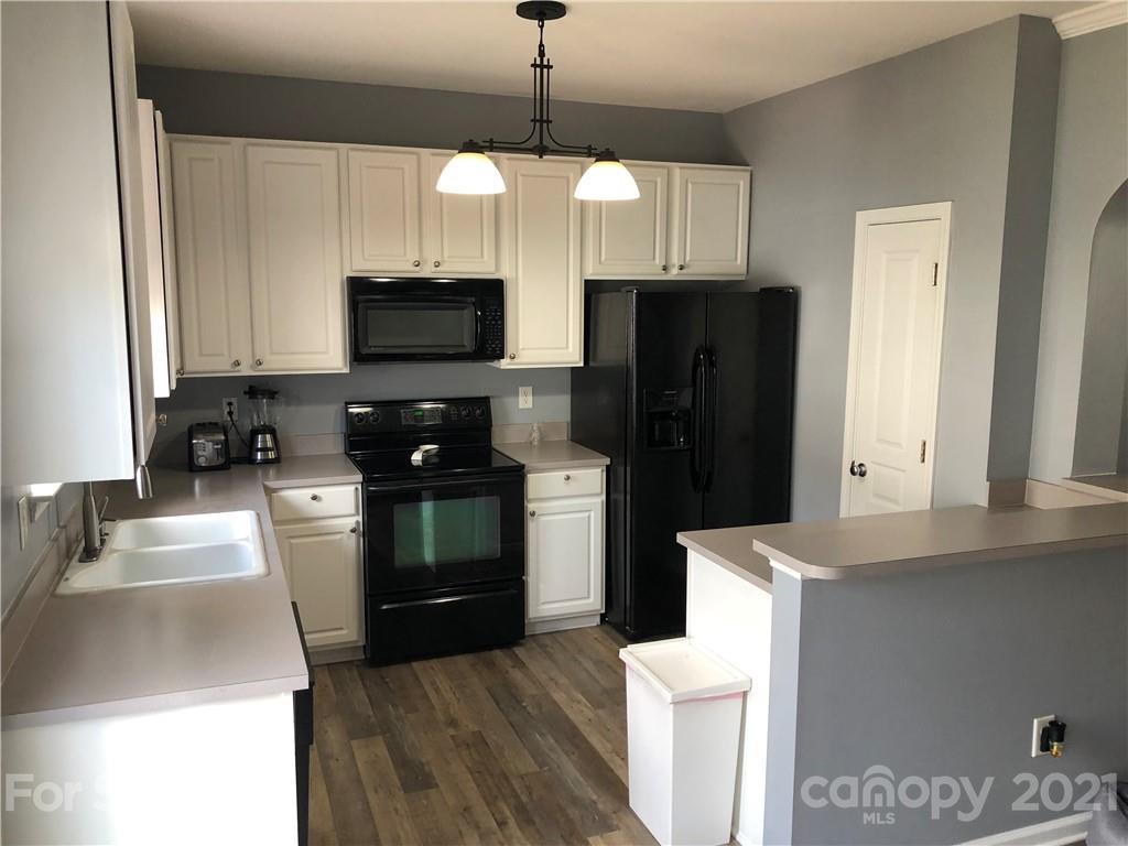 123 Chimney Rock Lane Fort Mill, SC 29708 - Photo 4 of 30 a kitchen with stainless steel appliances granite countertop a refrigerator a stove a microwave and a sink with wooden floor