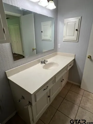 a bathroom with a sink vanity and a mirror