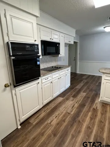 a kitchen with stainless steel appliances a stove a microwave and sink