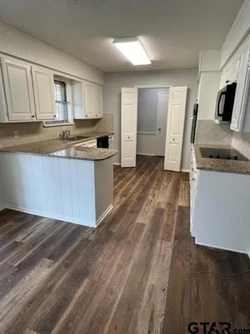 a kitchen with granite countertop a stove and a sink