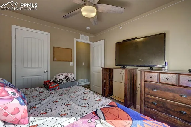 a bedroom with a large bed and a chandelier