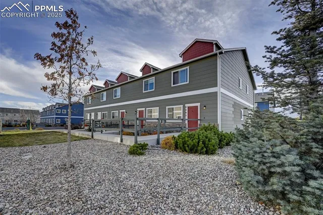 a front view of a house with a yard and trees