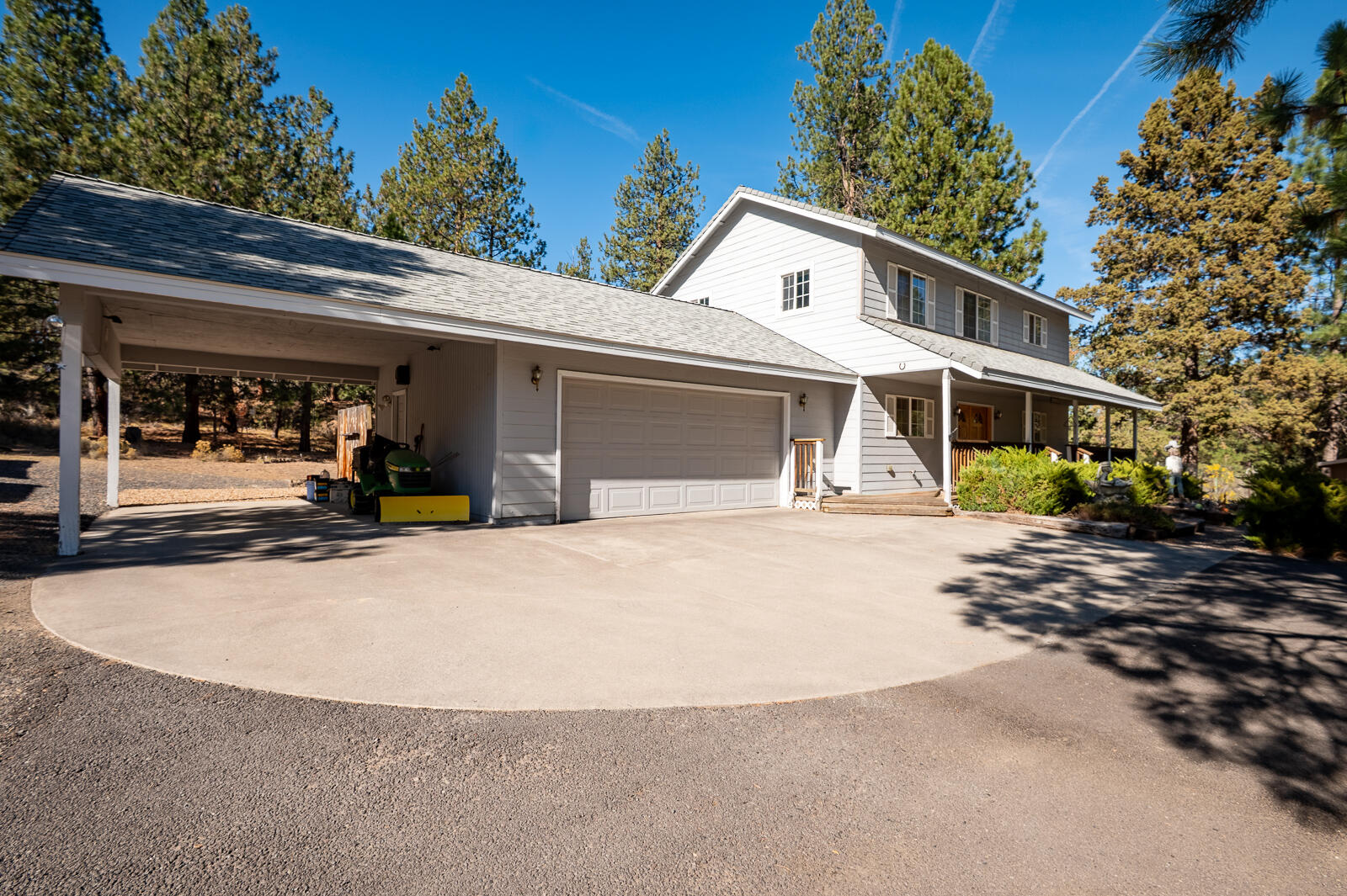 19793 Buck Canyon Road Bend, OR 97702 - Photo 3 of 33 a view of a white house with large windows and plants