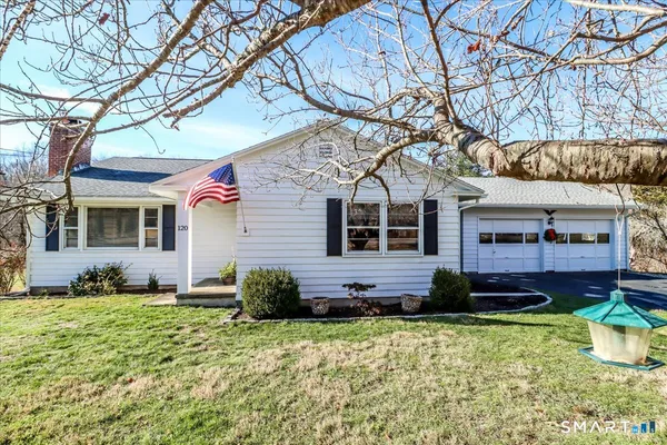 a front view of a house with a yard and potted plants