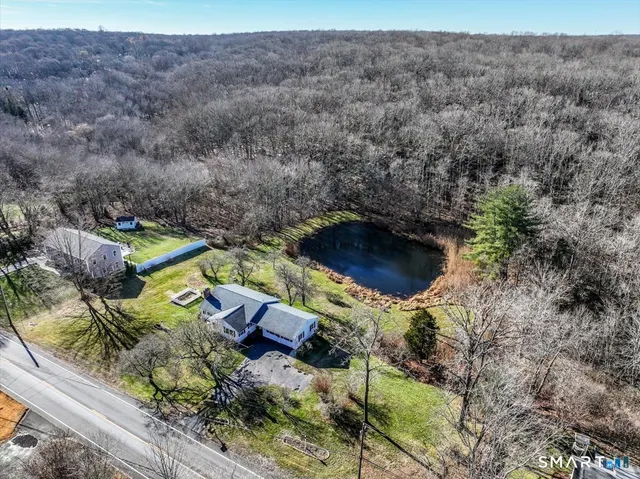 an aerial view of a house with a yard and lake view