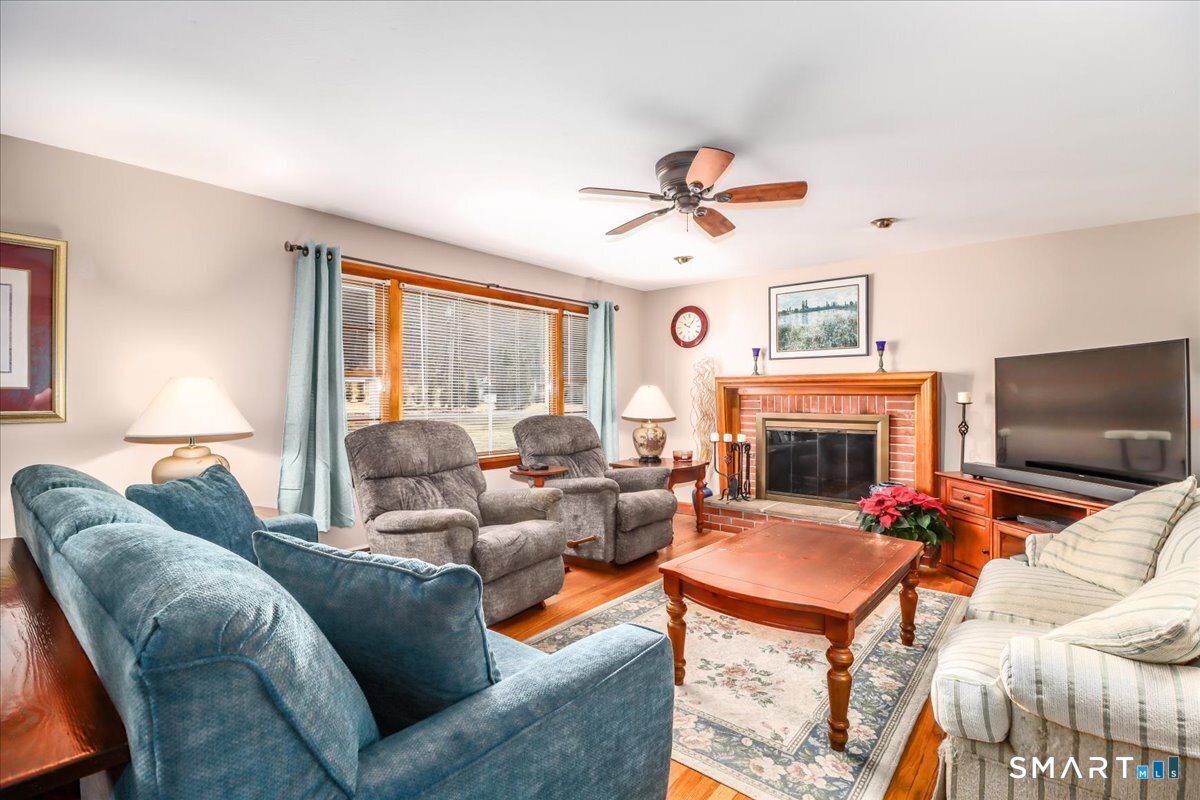 120 Warsaw Street Deep River, CT 06417 - Photo 6 of 39 a living room with furniture a fireplace and a flat screen tv
