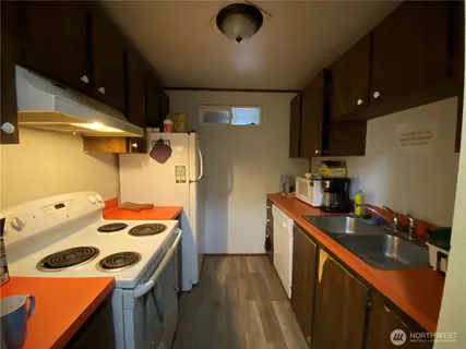 a kitchen that has a sink a stove and a refrigerator