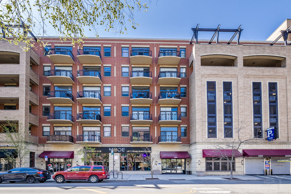 1301 West Madison Street, Unit 607 Chicago, IL 60607 - Photo 1 of 39 a front view of an apartment building with a yard