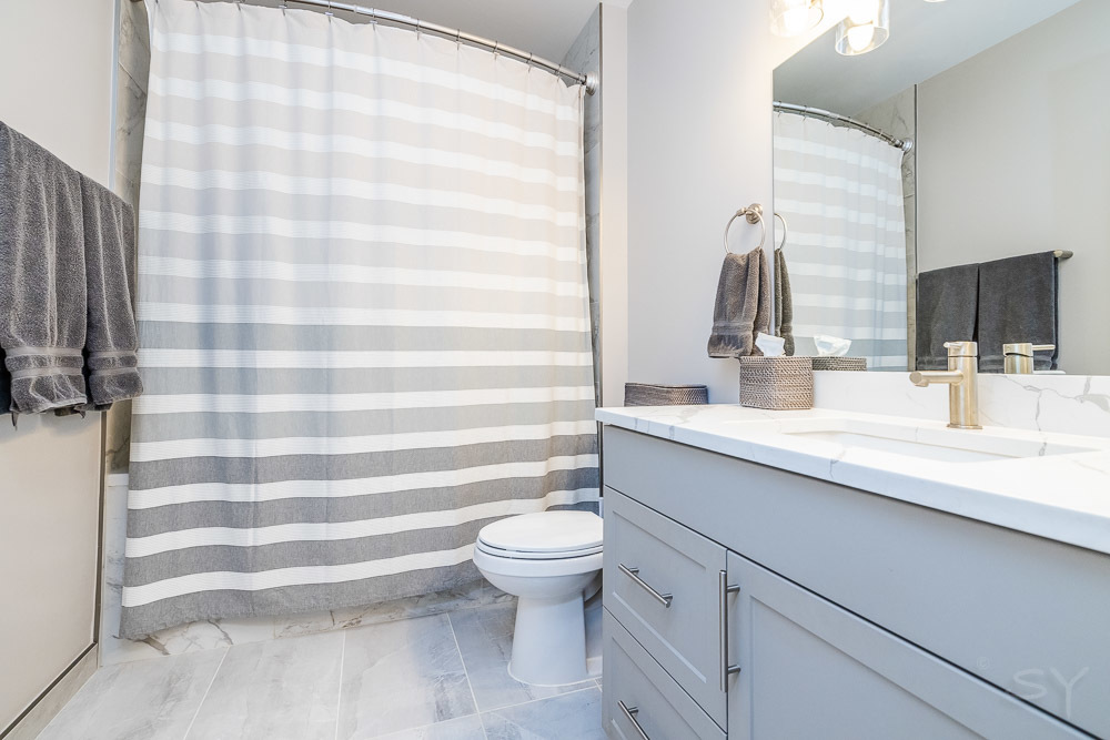 1301 West Madison Street, Unit 607 Chicago, IL 60607 - Photo 20 of 39 a bathroom with a sink a toilet a mirror and shower curtain