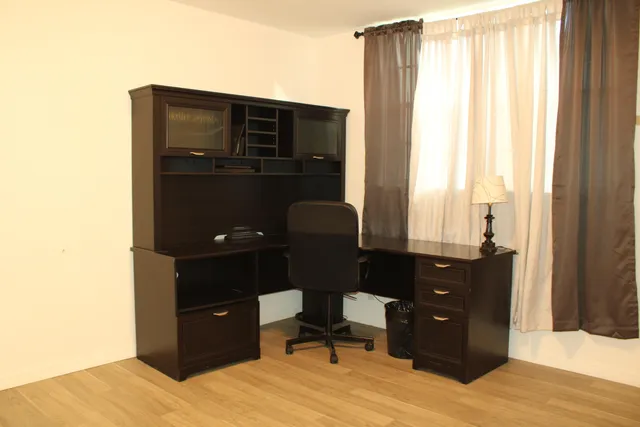 a living room with a dresser and a chair