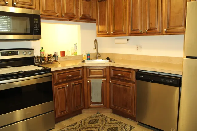 a kitchen with stainless steel appliances granite countertop a stove a sink and a microwave