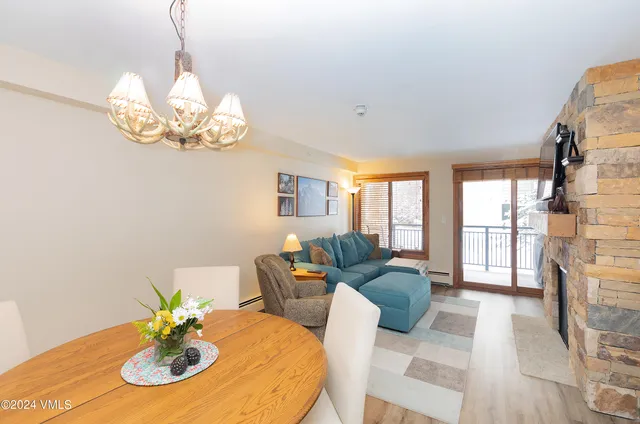 a living room with furniture chandelier and a fireplace
