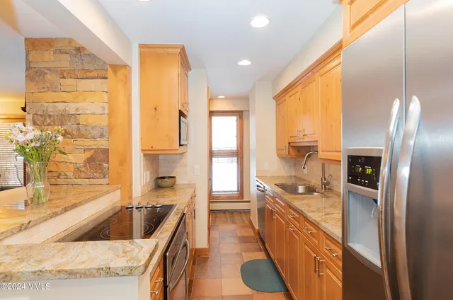 a large kitchen with a large window and stainless steel appliances