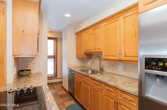 a kitchen with a sink a stove and cabinets