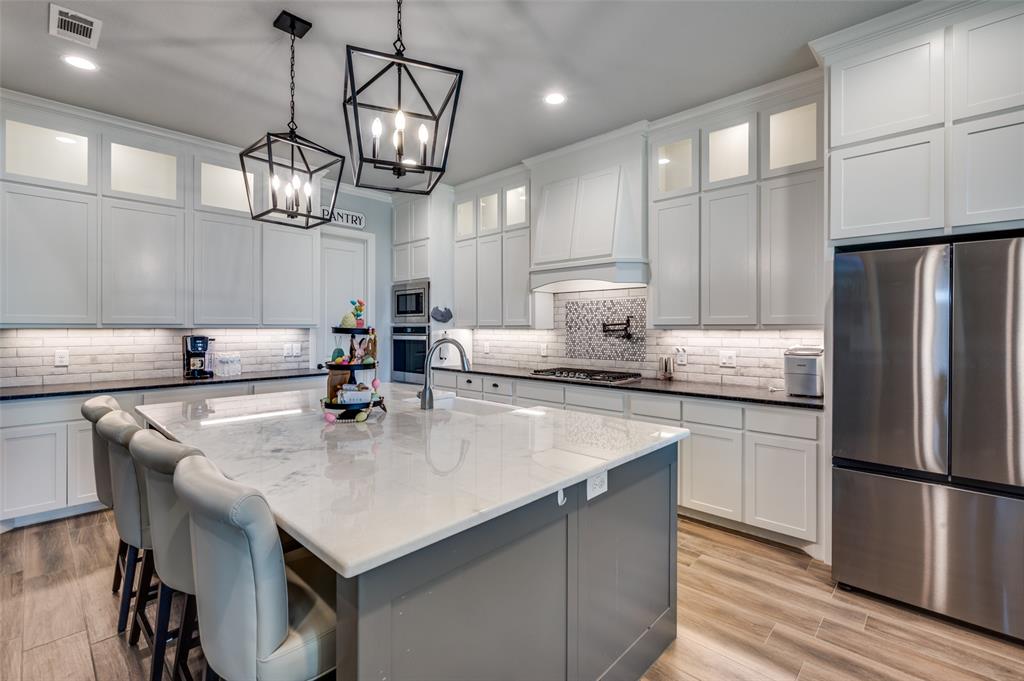 131 San Miguel Drive Decatur, TX 76234 - Photo 12 of 40 a kitchen with kitchen island granite countertop a sink a center island and stainless steel appliances