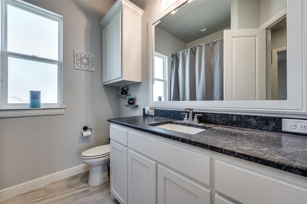 131 San Miguel Drive Decatur, TX 76234 - Photo 32 of 40 a bathroom with a granite countertop toilet sink and mirror