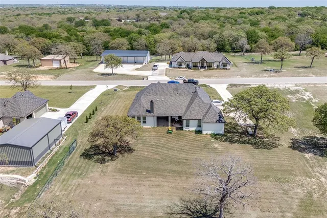 an aerial view of a house with a yard basket ball court and outdoor seating