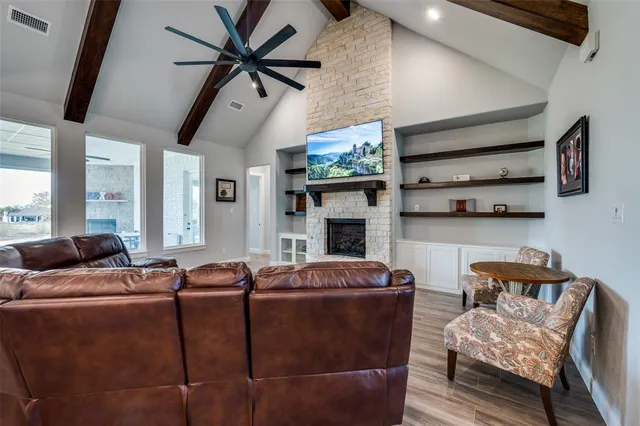 a living room with furniture fireplace and a large window