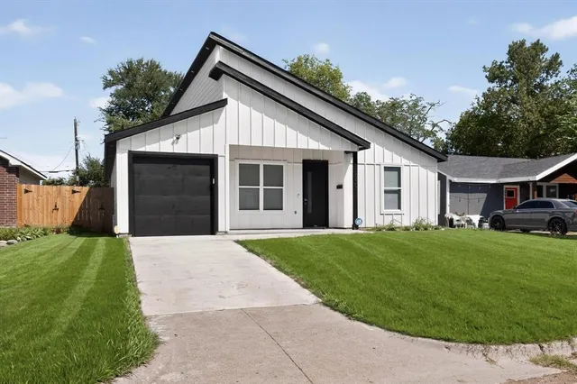 a front view of a house with a garden and yard