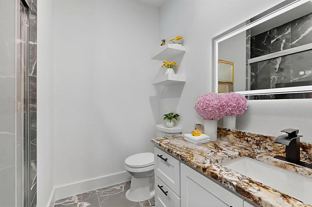 3901 Le May Avenue Dallas, TX 75216 - Photo 4 of 14 a bathroom with a granite countertop sink a toilet and a window