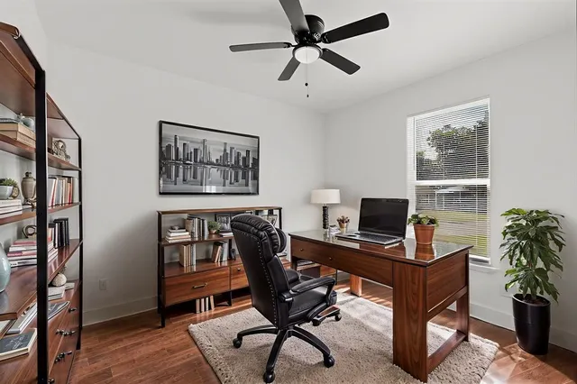 a view of a workspace with furniture and a window