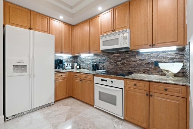 230 Ocean Grande Boulevard, Unit 802 Jupiter, FL 33477 - Photo 20 of 42 a kitchen with stainless steel appliances granite countertop a refrigerator sink and cabinets