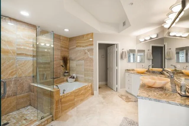 a spacious bathroom with a granite countertop sink a toilet a mirror and shower