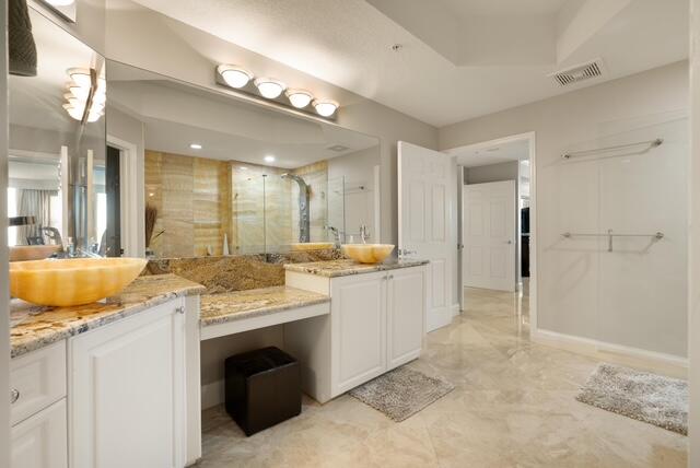 230 Ocean Grande Boulevard, Unit 802 Jupiter, FL 33477 - Photo 30 of 42 a spacious bathroom with a granite countertop sink a toilet a mirror and shower