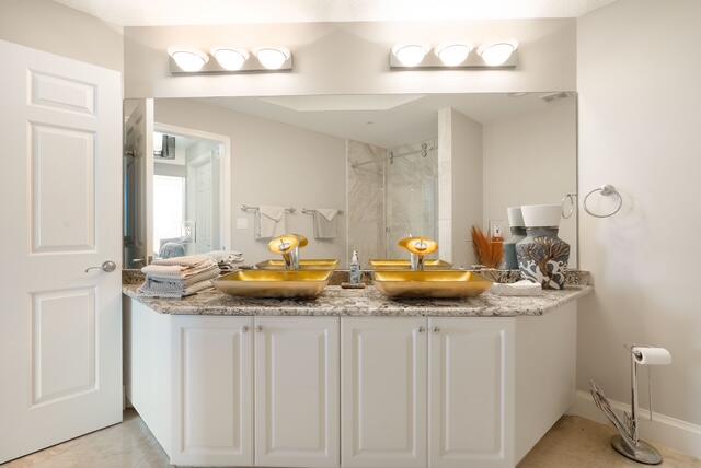 230 Ocean Grande Boulevard, Unit 802 Jupiter, FL 33477 - Photo 35 of 42 a bathroom with a granite countertop sink and a mirror