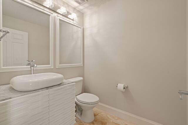 230 Ocean Grande Boulevard, Unit 802 Jupiter, FL 33477 - Photo 38 of 42 a bathroom with a granite countertop toilet and sink