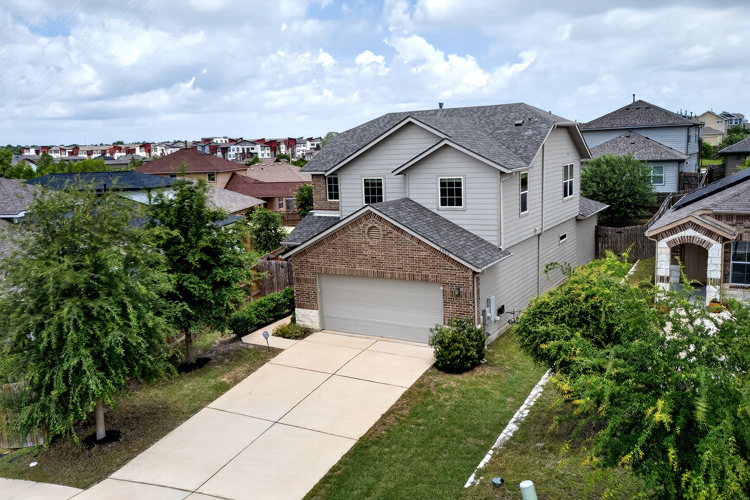 2006 Grow Lane Austin, TX 78754 - Photo 2 of 40 A classic two-story residence presents an inviting facade with a brick and siding blend, complemented by a neatly paved driveway.