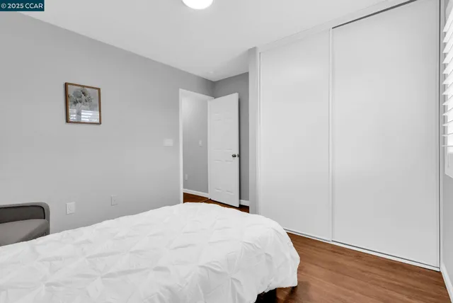 a bedroom with a bed and wooden floor